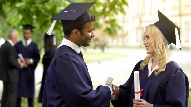 International graduate shaking hands with a new employer in a professional setting, symbolizing the successful career outcome of securing an education loan.