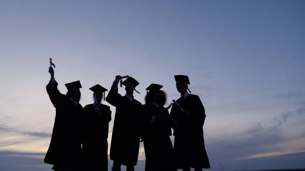 Diverse group of international students celebrating graduation with a city skyline in the background, symbolizing career success abroad.